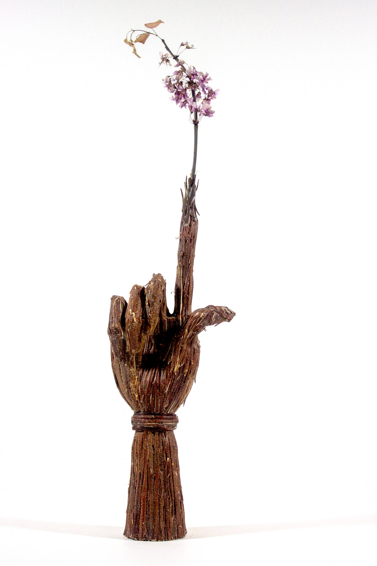 Charlie’s Tree, a sculpted hand covered in redbud bark growing a flowing branch from its finger, by McKlveen.